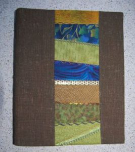 Ringbind med tekstilt omslag, syet med crazy patchwork.