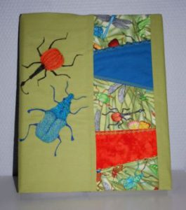 Ringbind med tekstilt omslag, syet med crazy patchwork og maskinbroderi