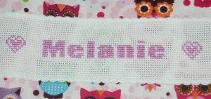 Sy baby-sengetøj med broderet navn.