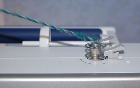 Lav snoet snore med spolen på symaskinen.